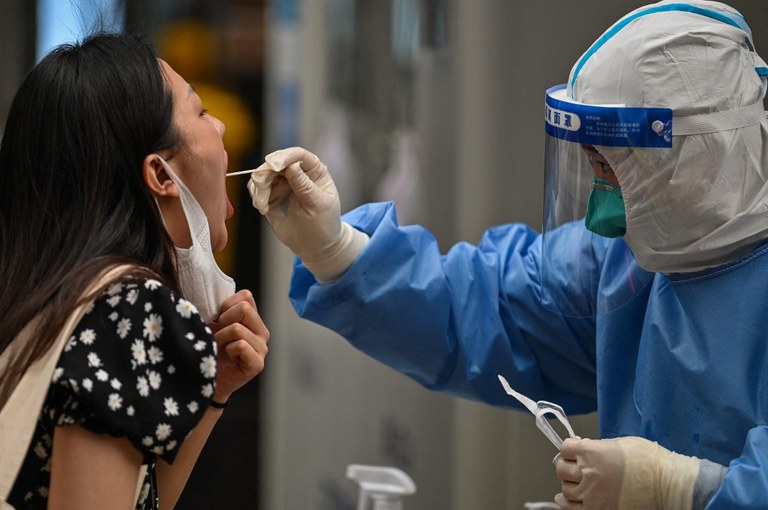 A health worker takes a swab sample from a woman in the Huangpu district of Shanghai on June 1, 2022. Credit: AFP