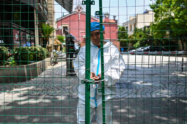 A worker padlocks fencing securing a residential area under Covid-19 lockdown in the Xuhui district of Shanghai on June 8, 2022. Credit: AFP