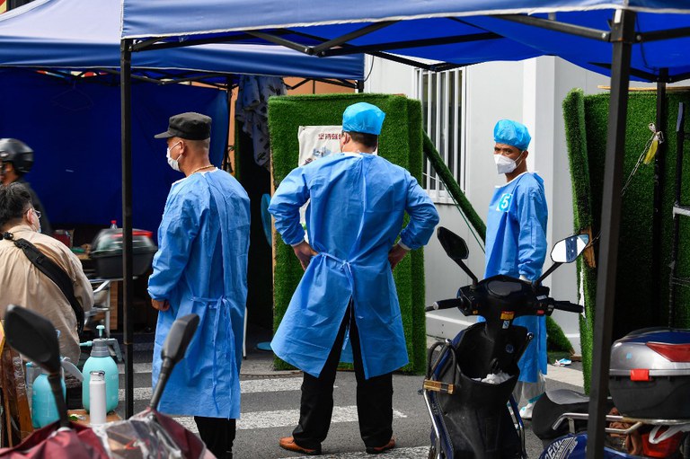 Community volunteers stand at an entrance in a residential area under a Covid-19 lockdown in Shanghai's Huangpu district, June 22, 2022. Credit: AFP