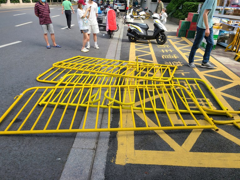 Yellow barriers lie scattered on the street during a protest against the COVID-19 lockdown order in Shanghai on May 30, 2022. Credit: Reuters