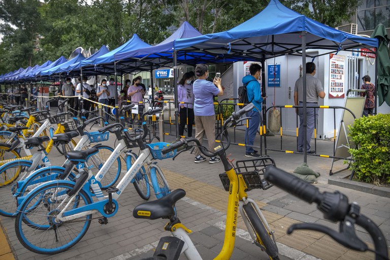 People stand in line at a COVID-19 testing site in Beijing on June 9, 2022. Thousands of testing booths have popped up on sidewalks across Beijing and other Chinese cities in the latest twist to the country's "zero-COVID" strategy. Credit: AP