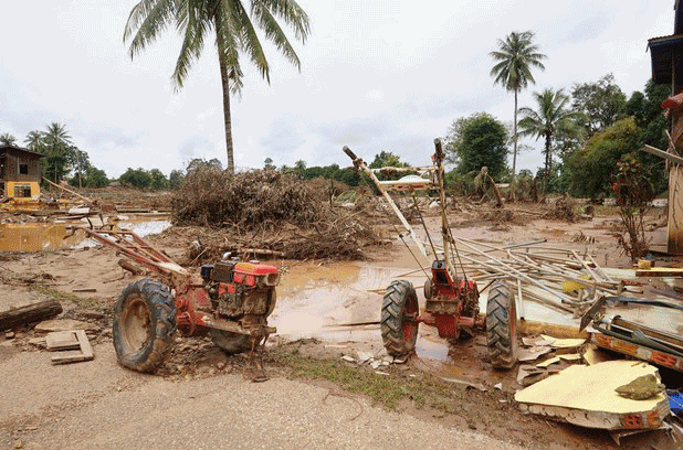 Small tractors stand idle in a former rice field covered by mud and other debris during flooding from a 2018 dam break, in southern Laos' Attapeu province, 2020. Credit: Citizen journalist.