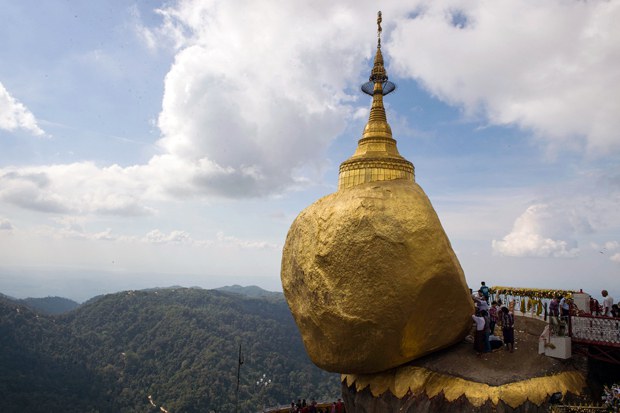 Devotees pray before a huge rock covered with layers of gold at the  Kyaiktiyo Pagoda on Mt. Kyaiktiyo, a popular Buddhist pilgrimage site and tourist attraction in southeastern Myanmar's Mon state, in a file photo. Credit: AFP
