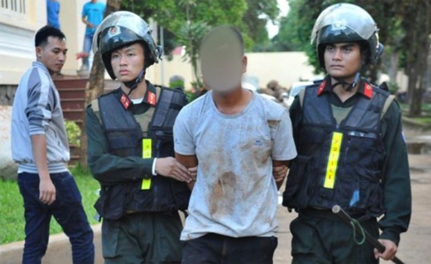 Vietnamese police officers escort a suspect arrested in Dak Lak province.  Credit: Vietnamese State media